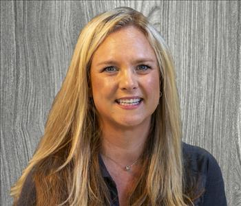 female employee posing in a black SERVPRO shirt, long blond hair