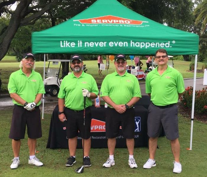Four SERVPRO employees standing in front of a SERVPRO tent.