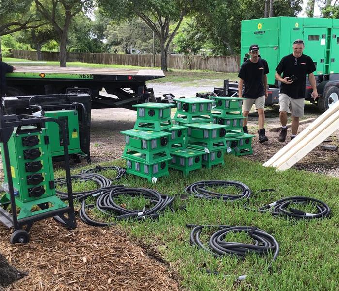 stacked green air movers in a field staging area