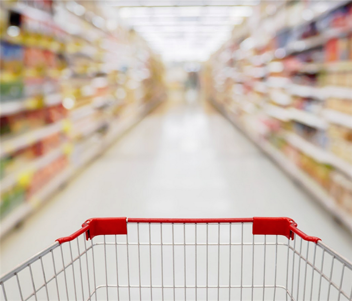 shopping cart view in supermarket aisle with product shelves abstract blur defocused background