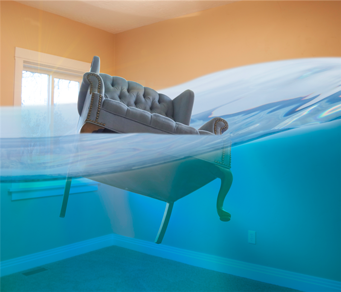 bedroom in house flooded with water and chair floating